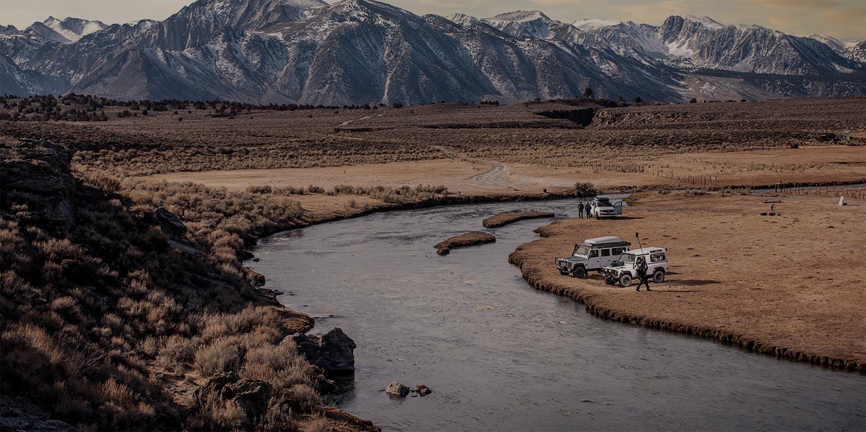 Land Rovers next to river
